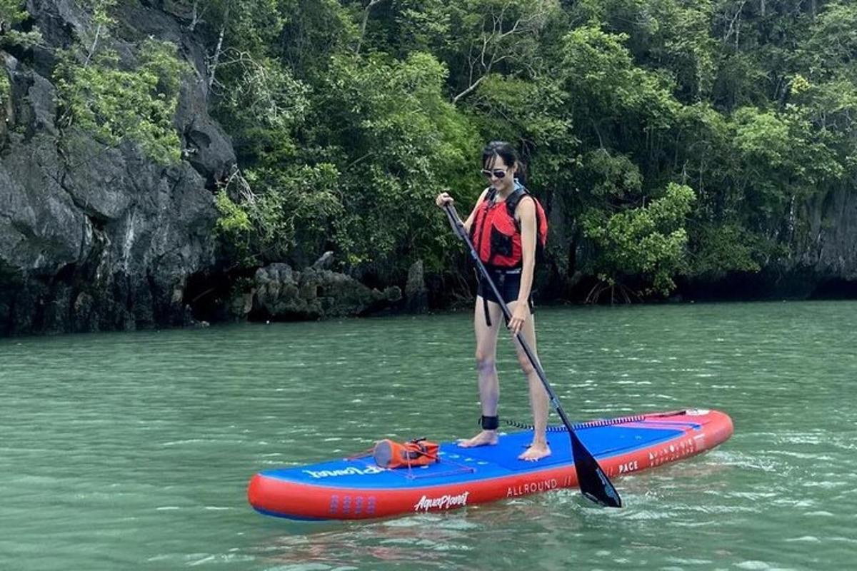 Žena stojí na paddleboardu ve vodě
