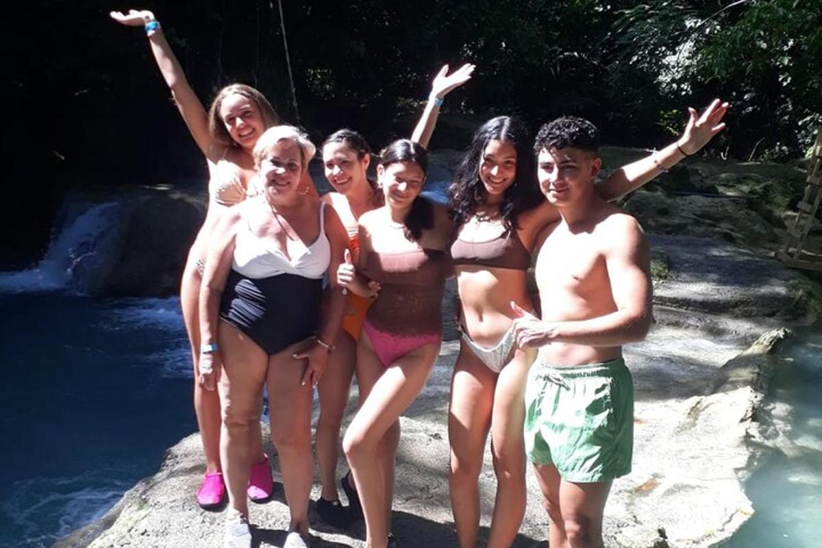 un gruppo di persone in posa per una foto vicino a una cascata