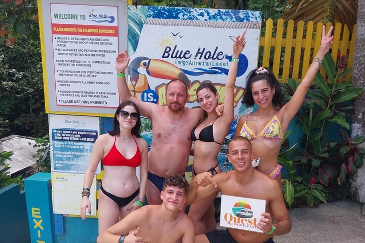 un gruppo di persone in costume da bagno in posa davanti a un cartello