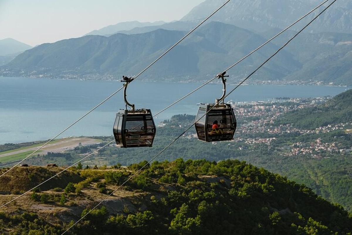 Dvě gondoly na lanovce letící nad horou