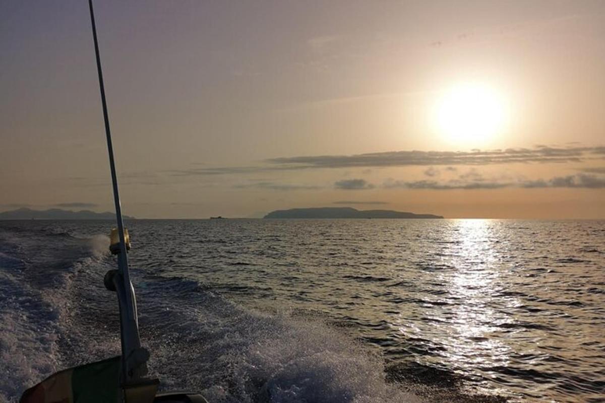 μια βάρκα στον ωκεανό με τον ήλιο στον ουρανό