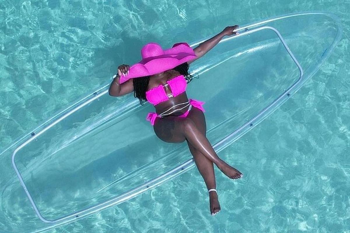 isang babaeng naka pink na damit at sombrerong nakahiga sa swimming pool