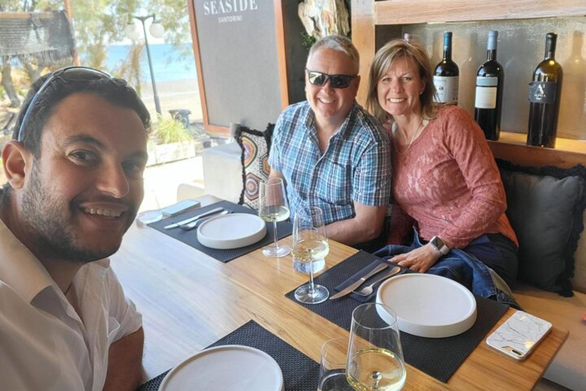 μια ομάδα ανθρώπων που κάθονται σε ένα τραπέζι με ποτήρια κρασιού