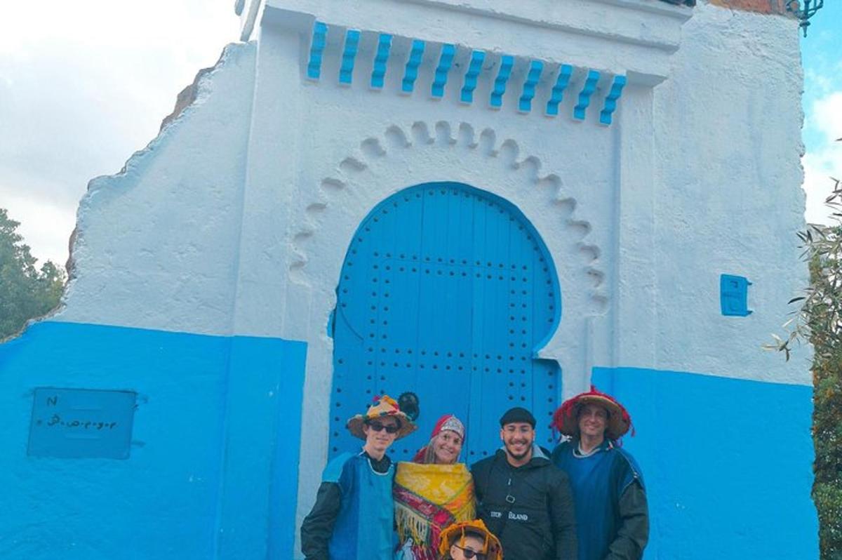 un gruppo di persone in piedi davanti a un edificio blu