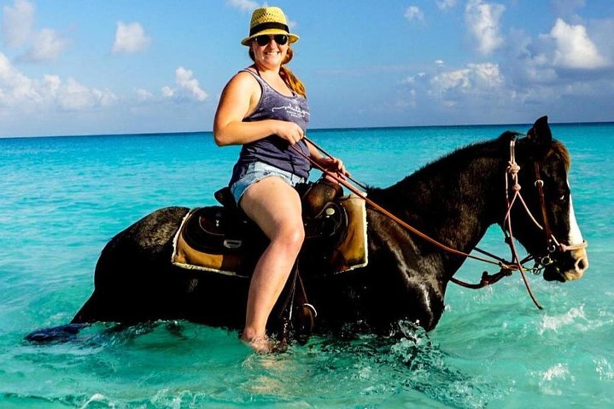 a woman riding a horse in the ocean