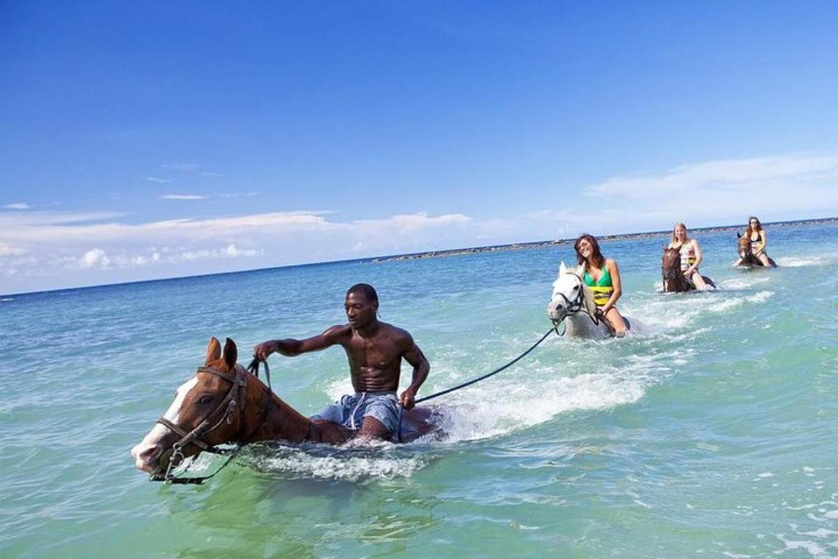 un bărbat călărește un cal în ocean