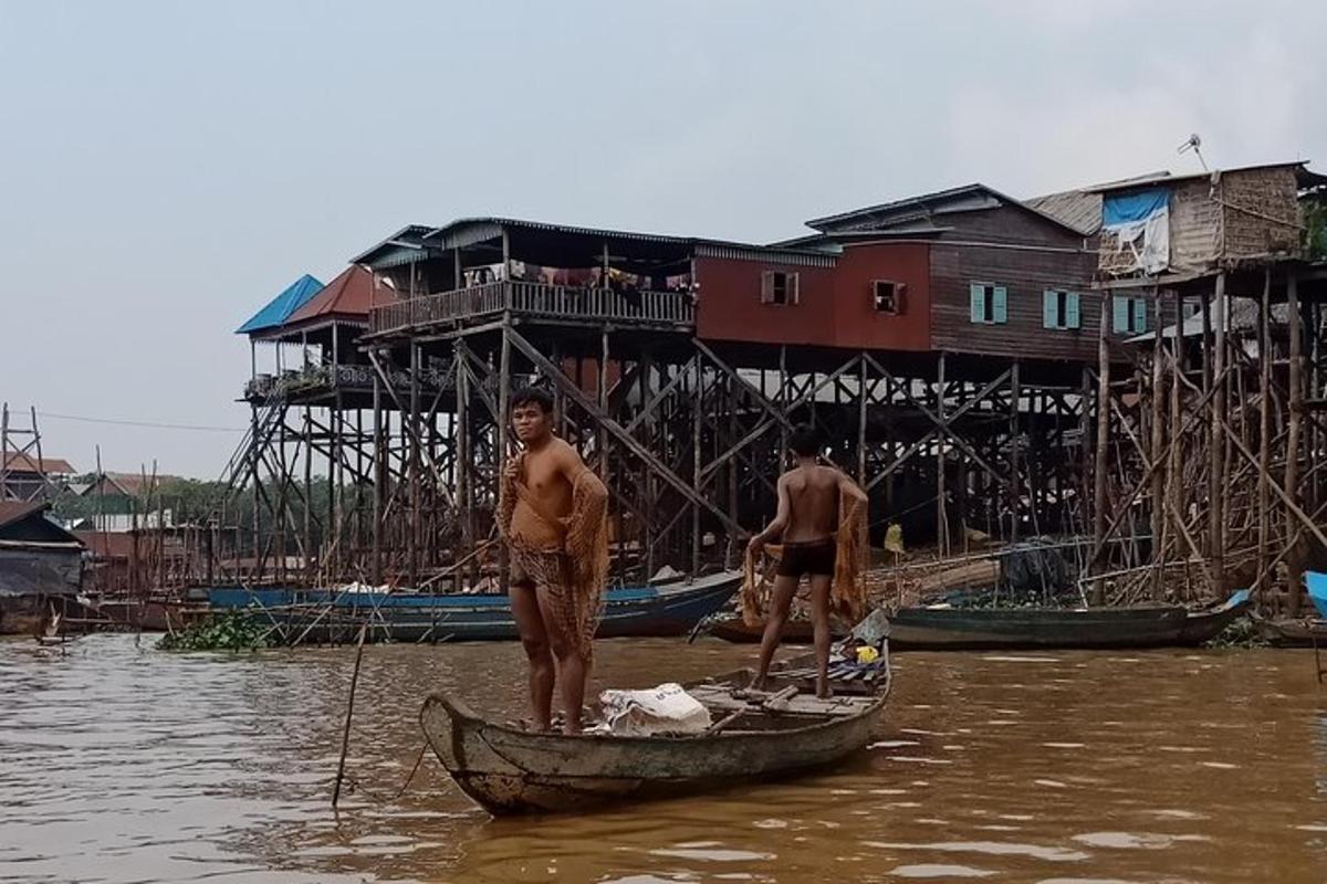 Dos hombres están parados en un bote en el agua.