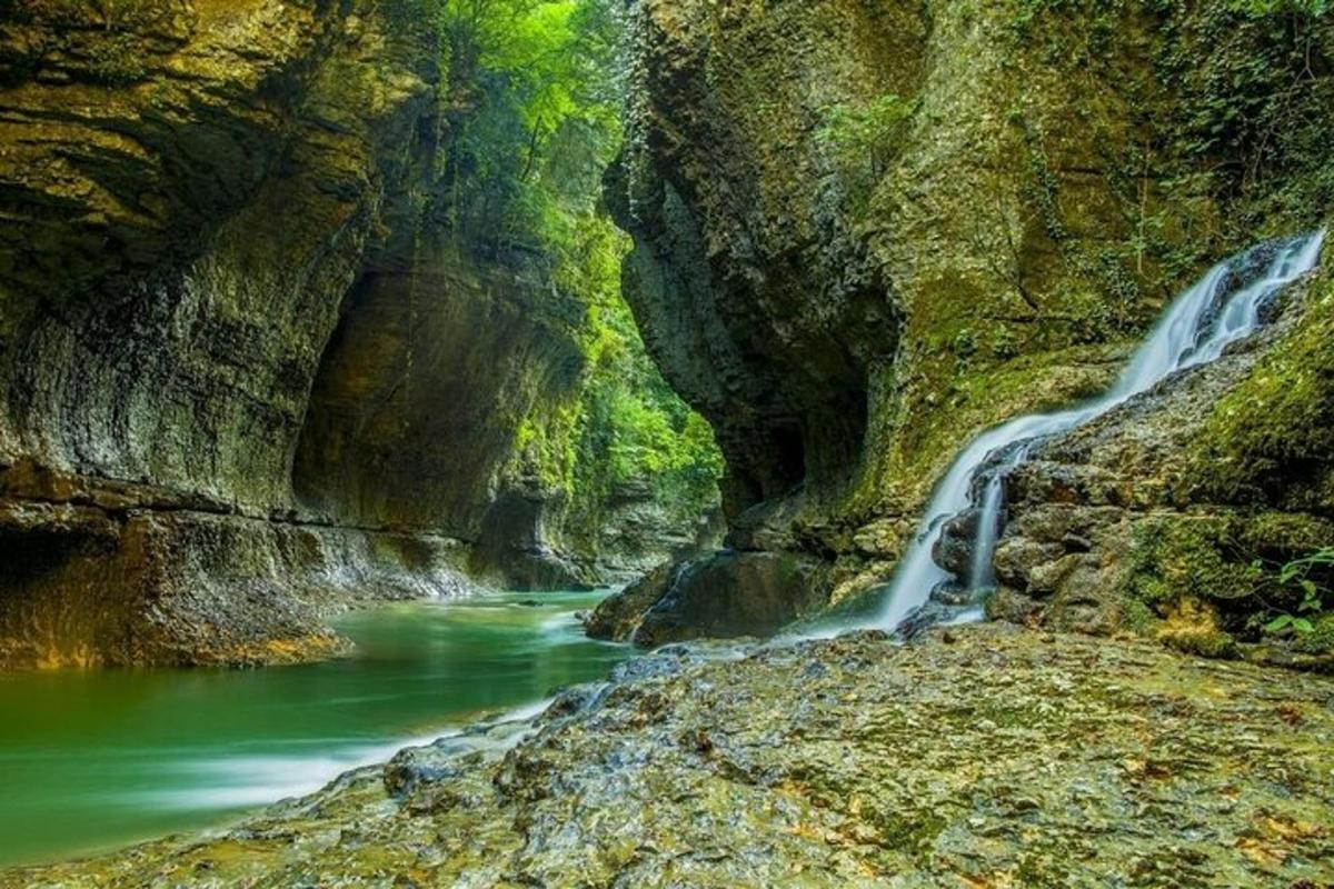a river in a canyon with a waterfall