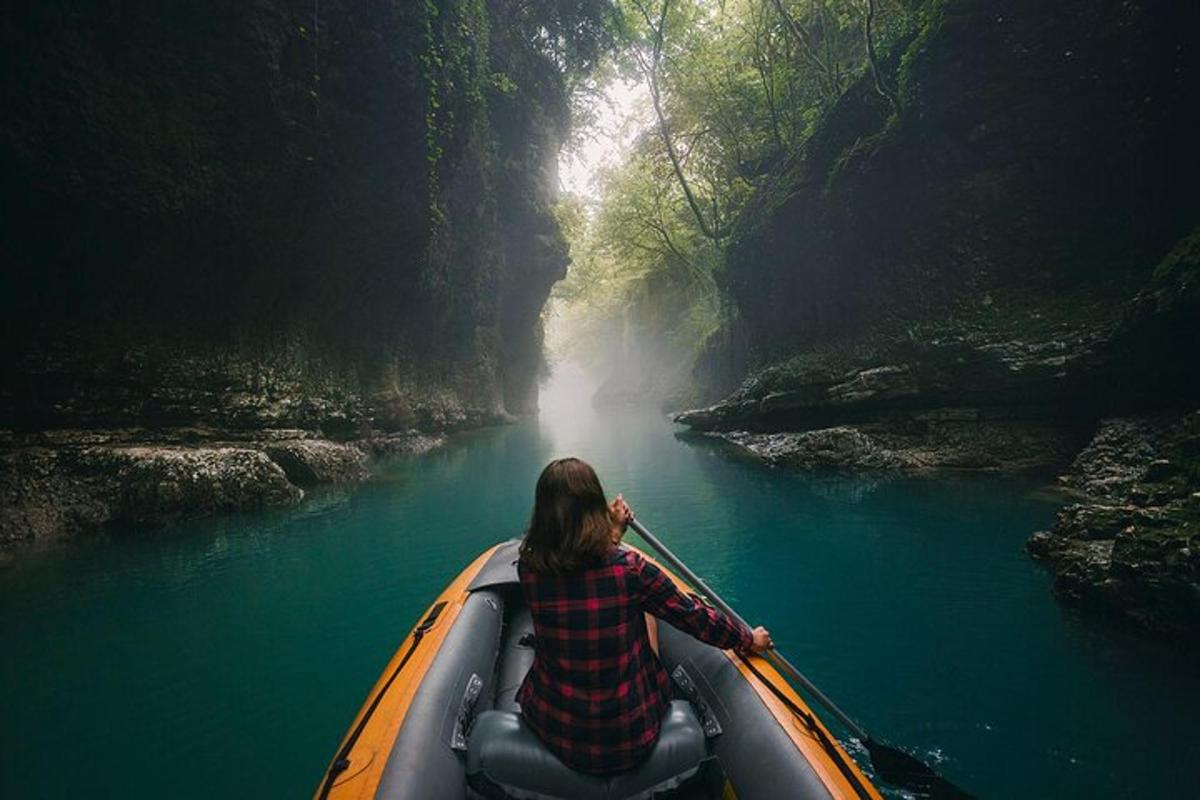 a woman is paddling a canoe in a river
