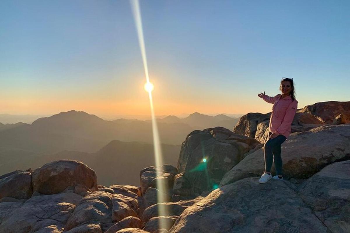una donna in piedi sulla cima di una montagna