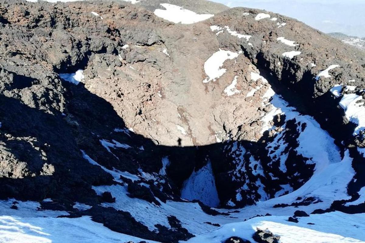 eine Luftaufnahme eines Berges mit Schnee darauf