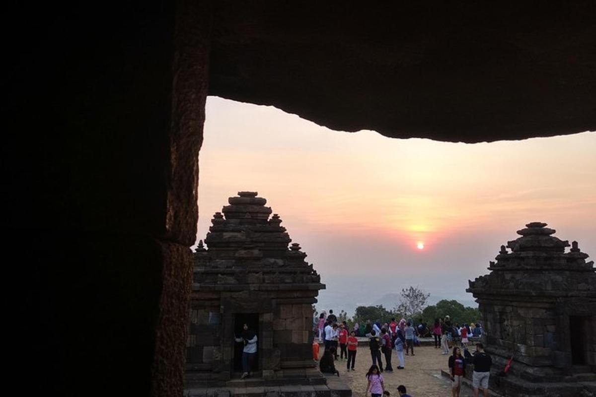 un groupe de personnes se promenant autour d'un temple au coucher du soleil