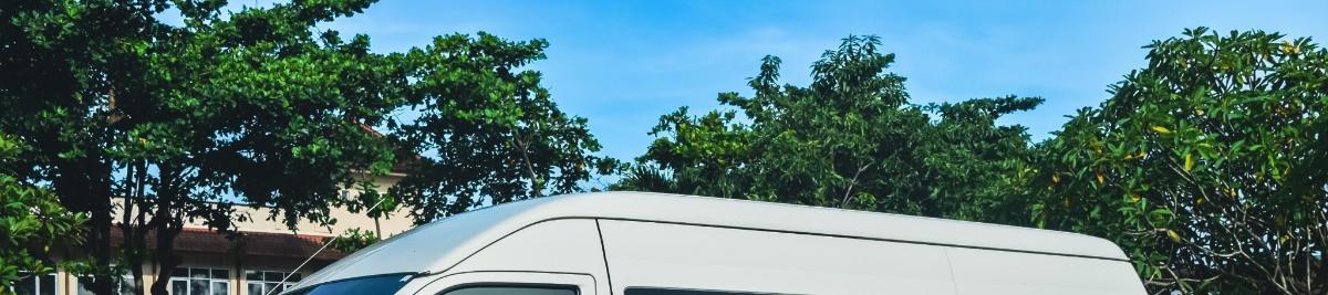 a white van parked in front of some trees