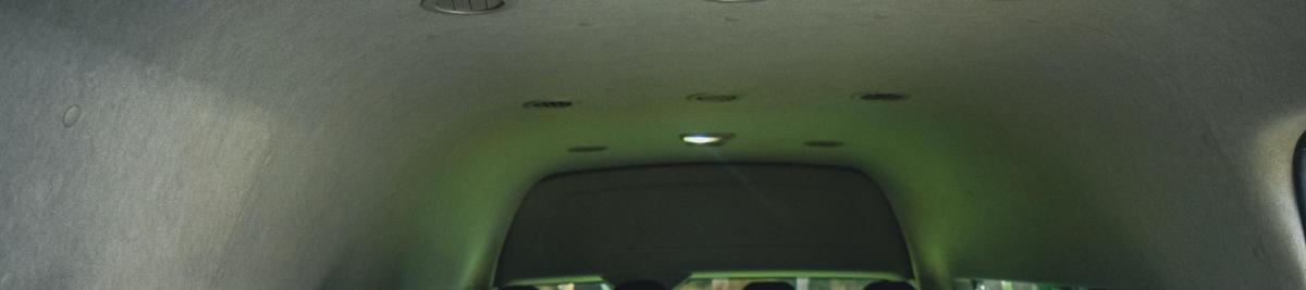 a hallway in a bus with a green ceiling