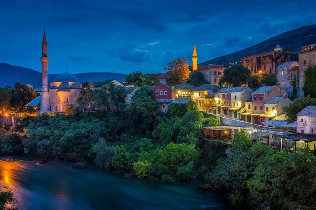 μια πόλη με ένα ποτάμι και ένα τζαμί τη νύχτα