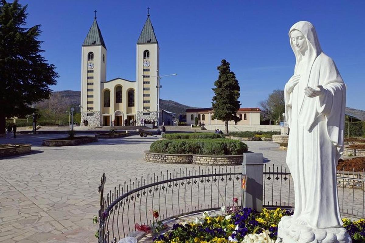 ένα άγαλμα ενός άνδρα που στέκεται μπροστά σε μια εκκλησία