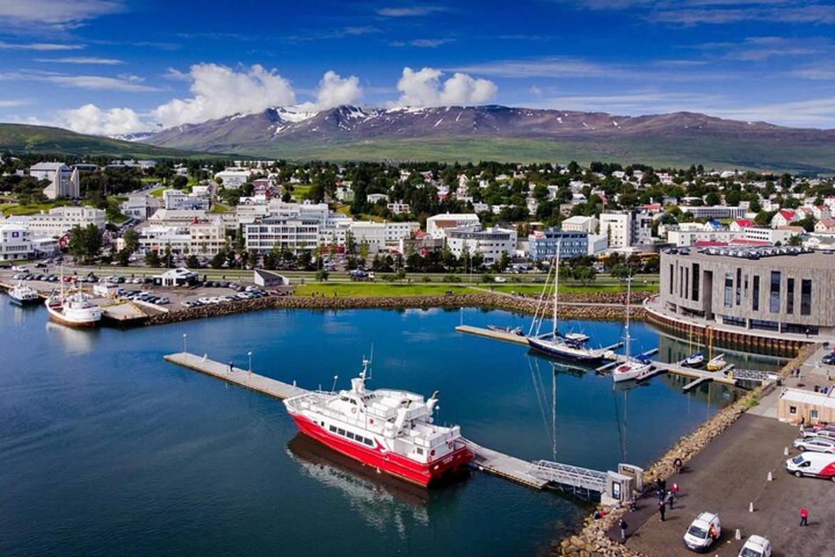 Rauður bátur lagður að bryggju við smábátahöfn í borginni
