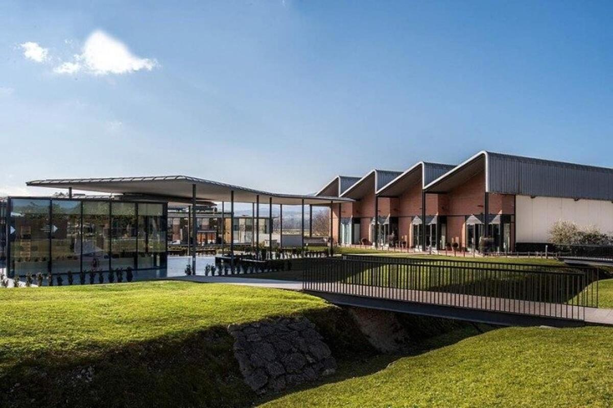 um grande edifício com um campo de grama na frente