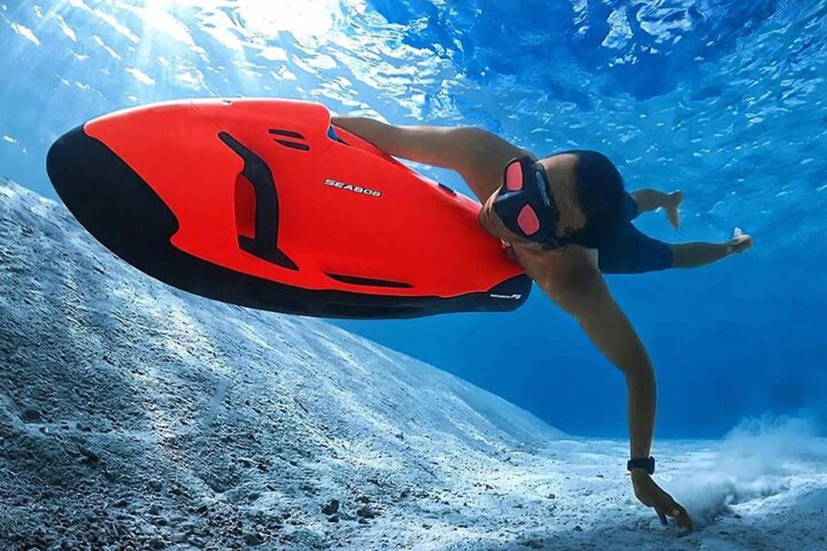 seseorang yang berenang di dalam air dengan papan merah