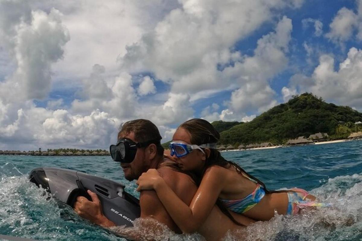 um homem e uma mulher em uma prancha de surfe na água