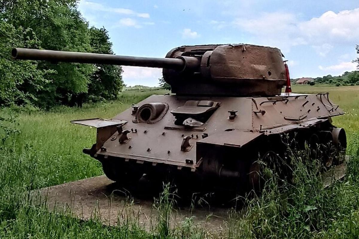 un carro armato appoggiato sul ciglio di un campo
