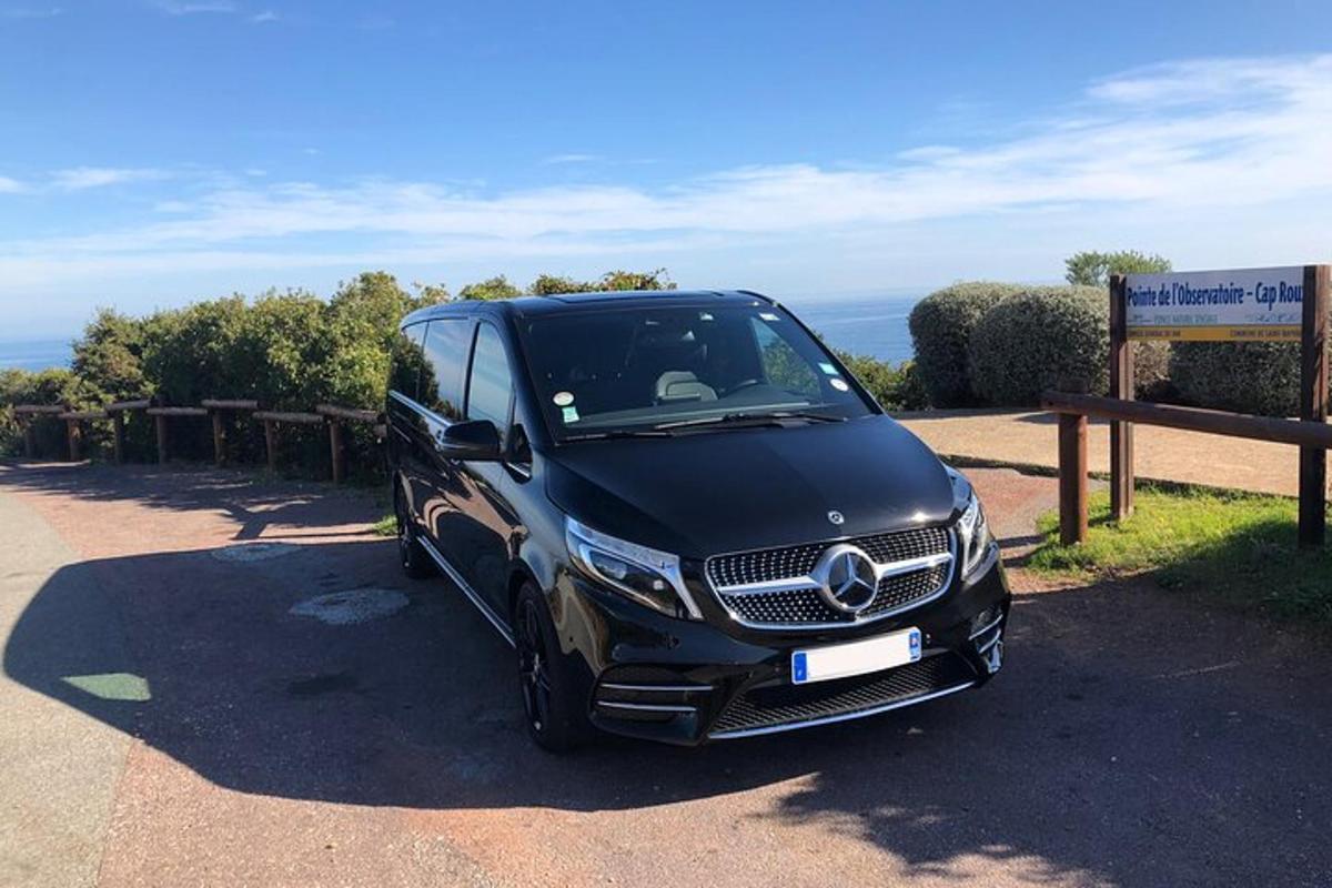 o dubă Mercedes Benz neagră parcată lângă un indicator