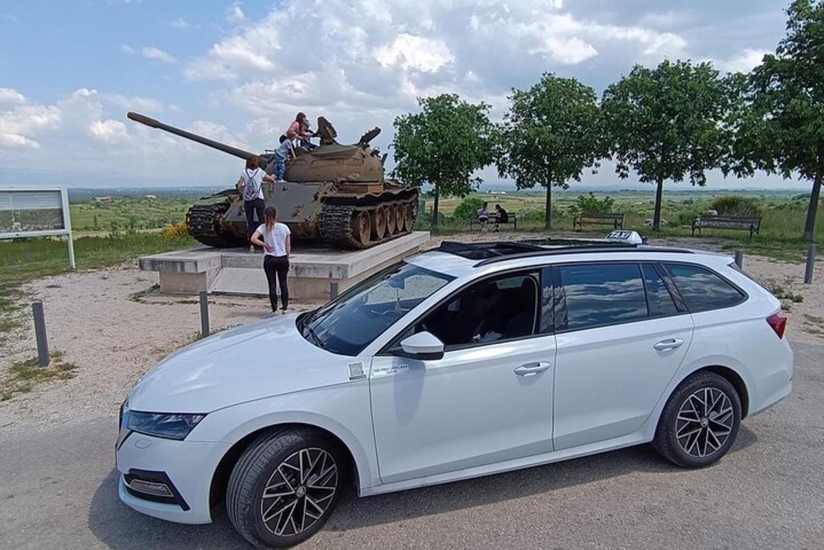 un'auto bianca parcheggiata davanti a un carro armato