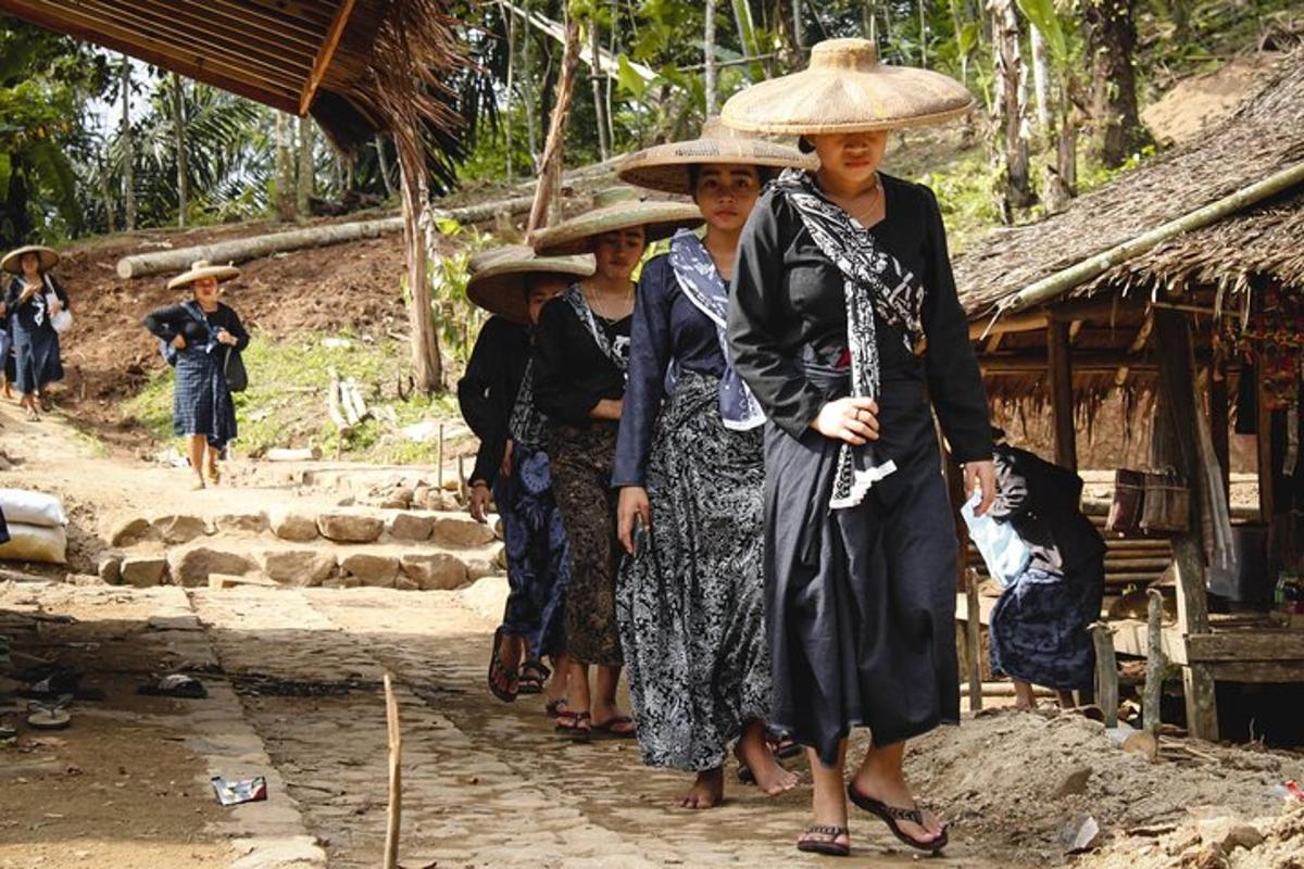 isang grupo ng mga babae na nakatayo sa harap ng isang kubo