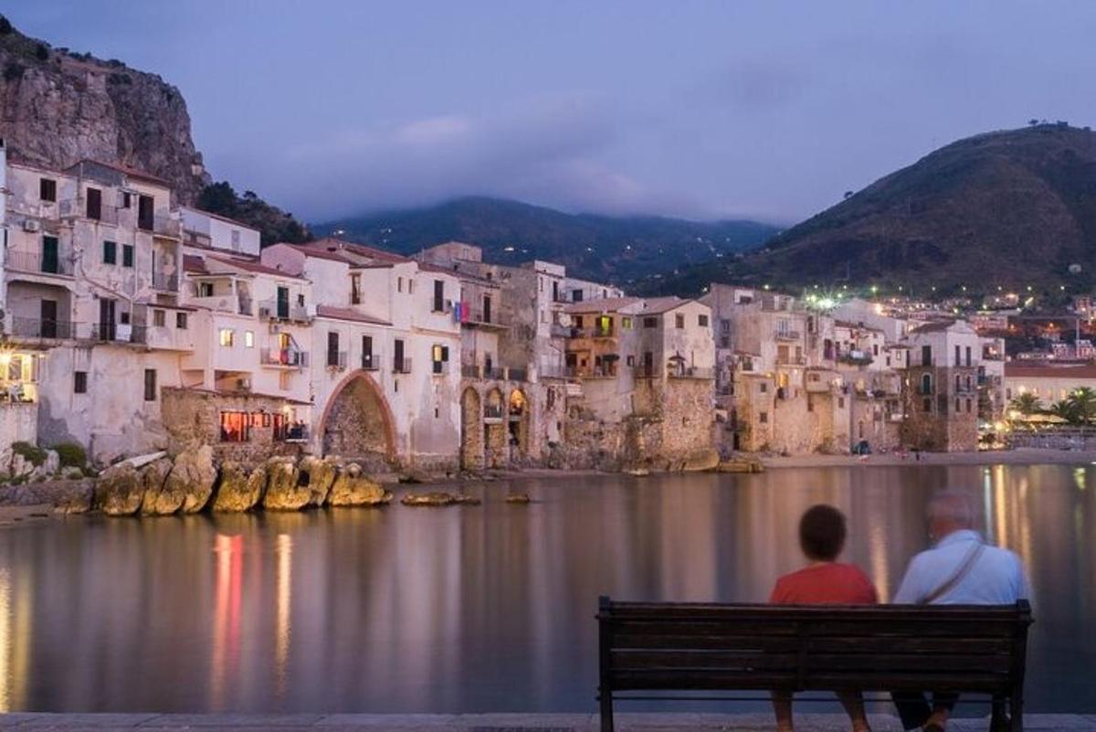 Δύο άνθρωποι κάθονται σε ένα παγκάκι μπροστά σε μια πόλη