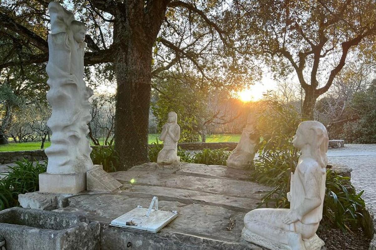 a group of statues sitting on steps in a park