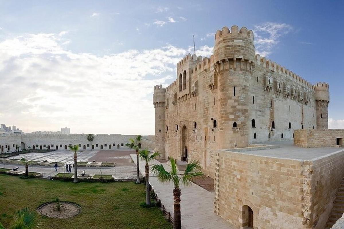 a large stone building with palm trees in front of it