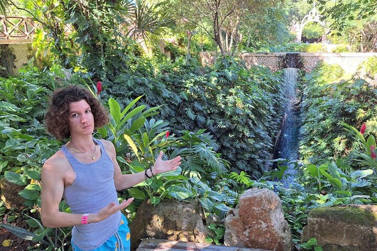una donna in piedi davanti a un giardino con una fontana