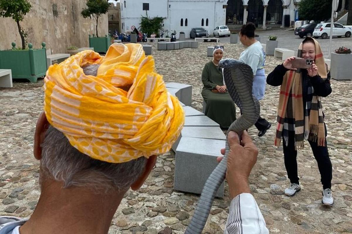 Un hombre tomando una fotografía de una persona con una toalla en la cabeza.