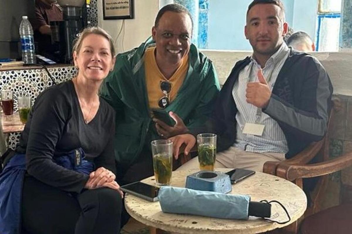 un grupo de tres personas sentadas alrededor de una mesa