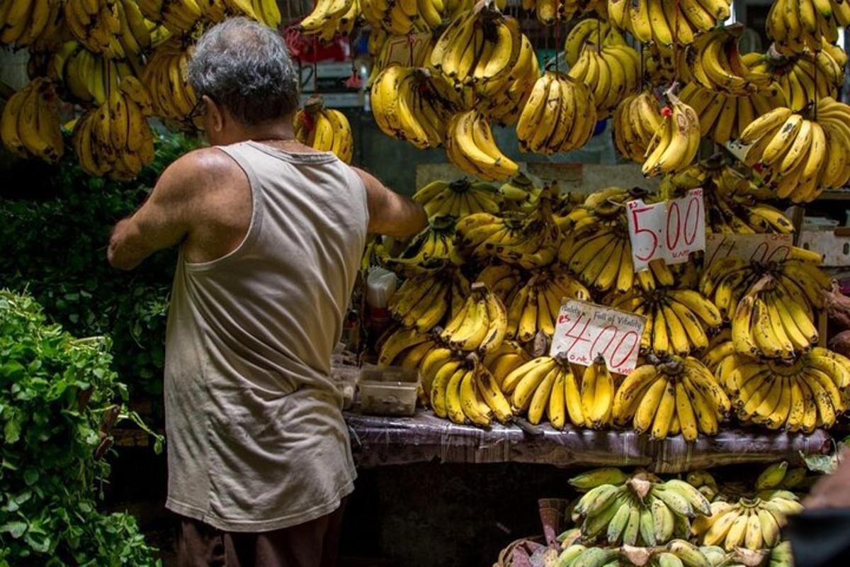 un uomo in piedi davanti a un tavolo di banane