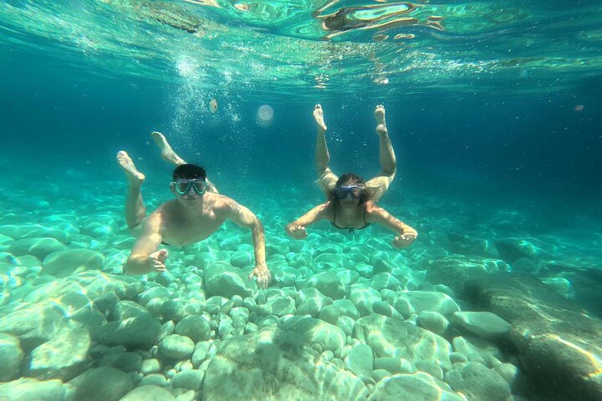 dva lidé plavají ve vodě v oceánu