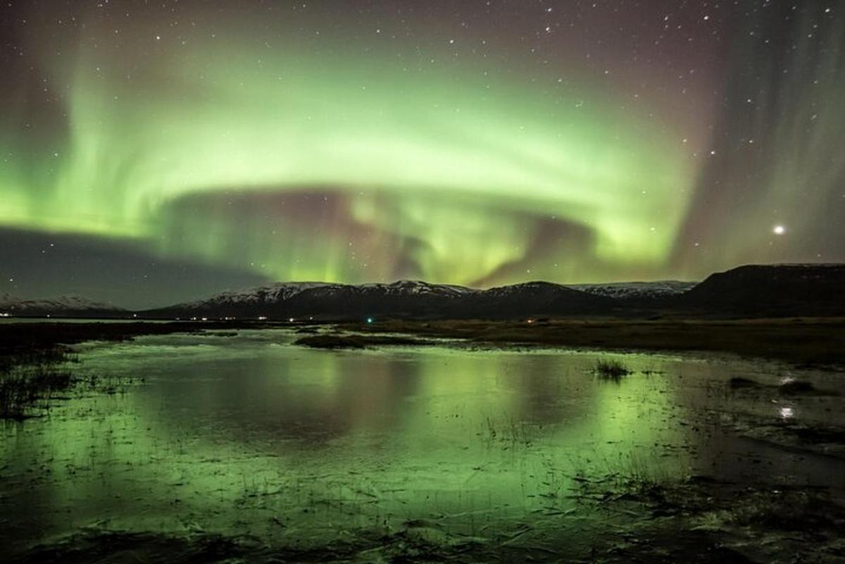 un'aurora sopra uno specchio d'acqua di notte
