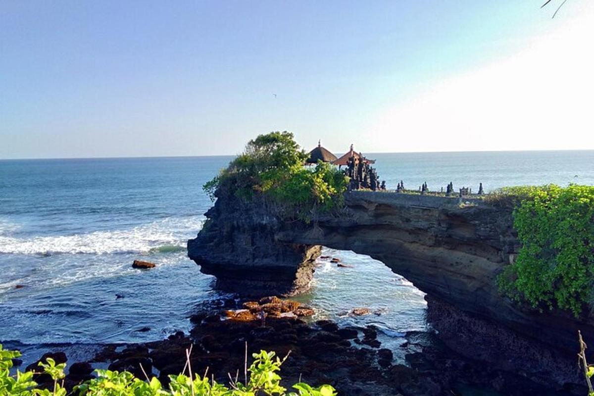 a group of people standing on a bridge over the ocean