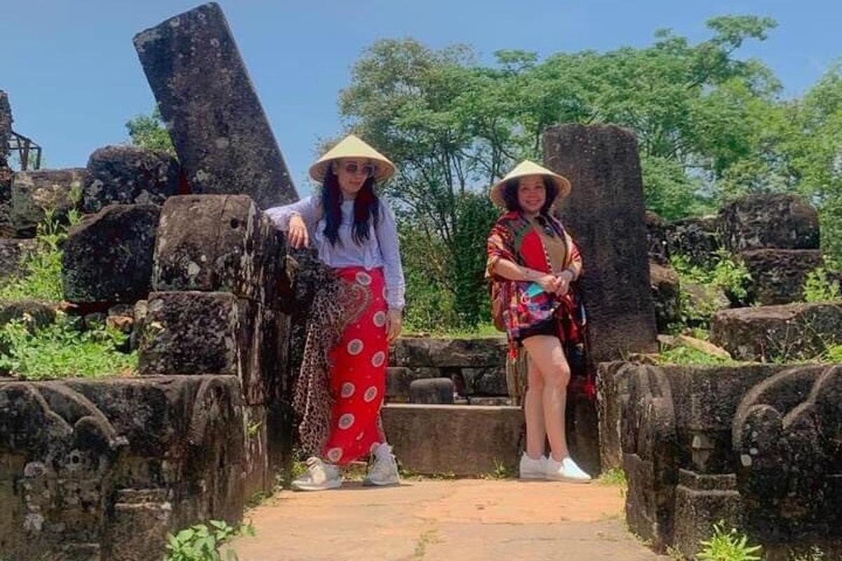 two women in hats standing on some rocks