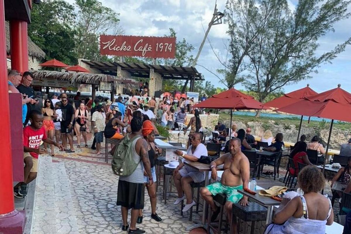 a crowd of people sitting at tables at a beach