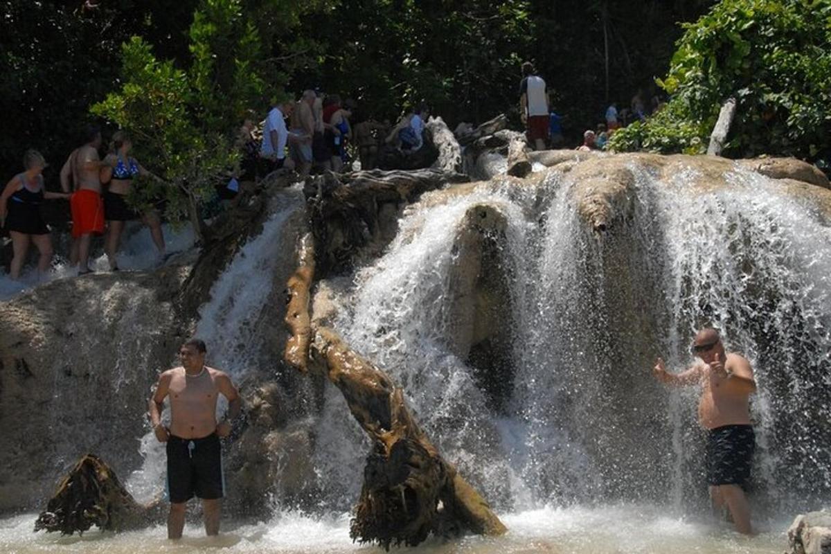 dois homens em pé em frente a uma cachoeira