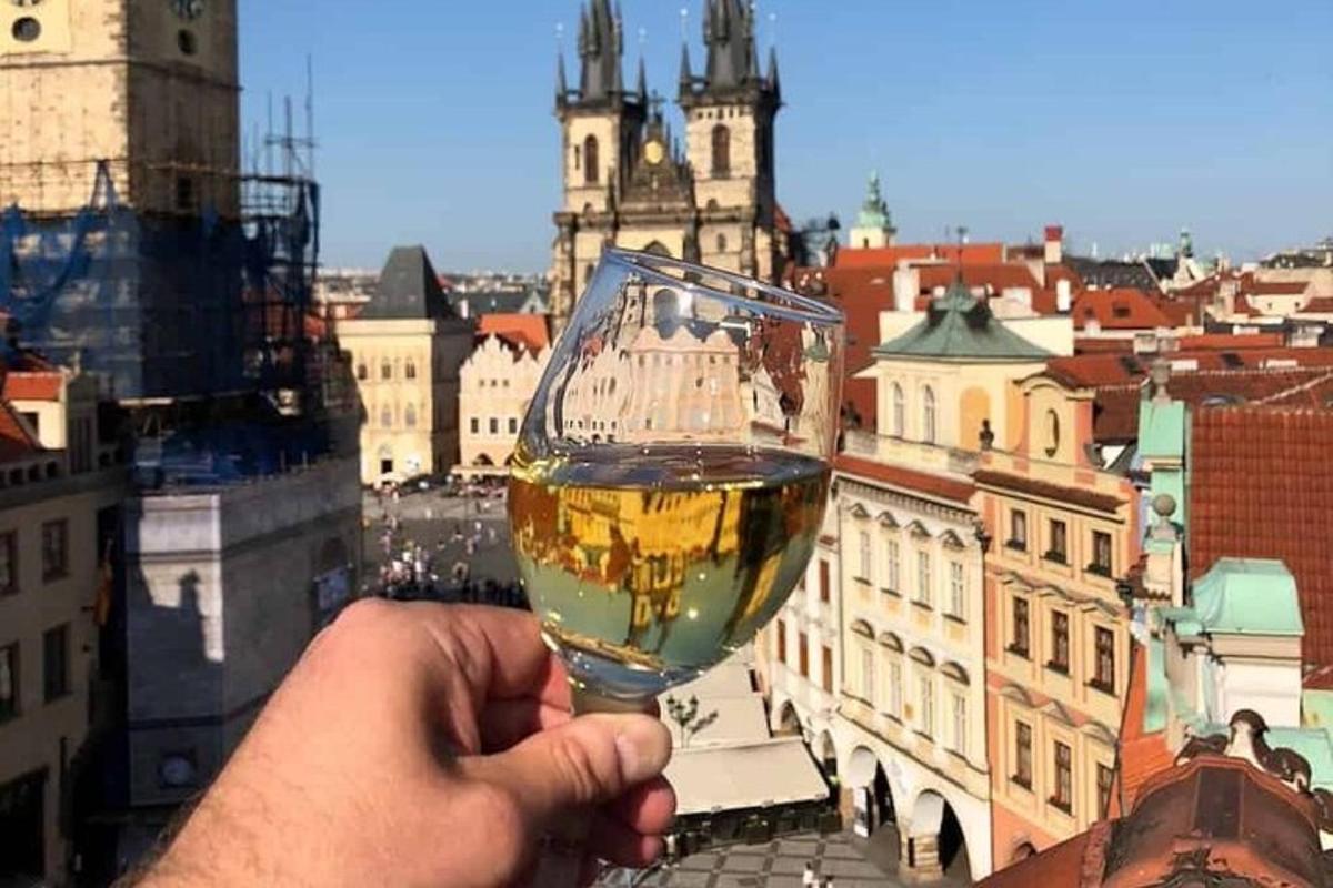 a person holding a glass of wine in front of a city