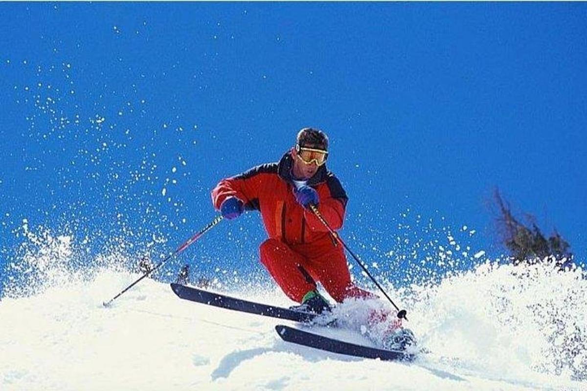 ein Mann fährt einen schneebedeckten Hang hinunter