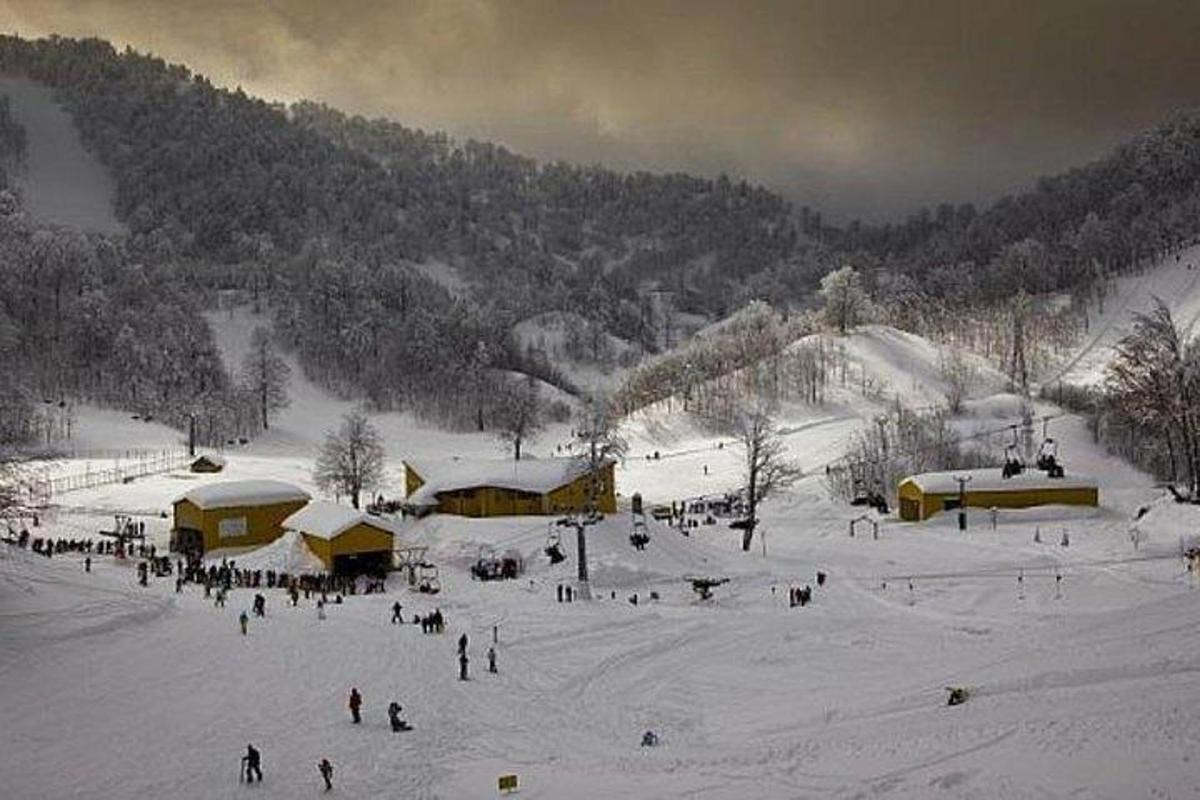 um grupo de pessoas na neve em uma pista de esqui