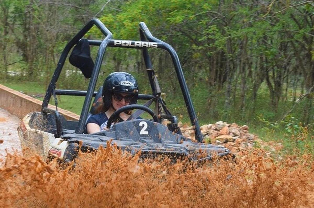 uma pessoa pilotando um quadriciclo em uma estrada de terra