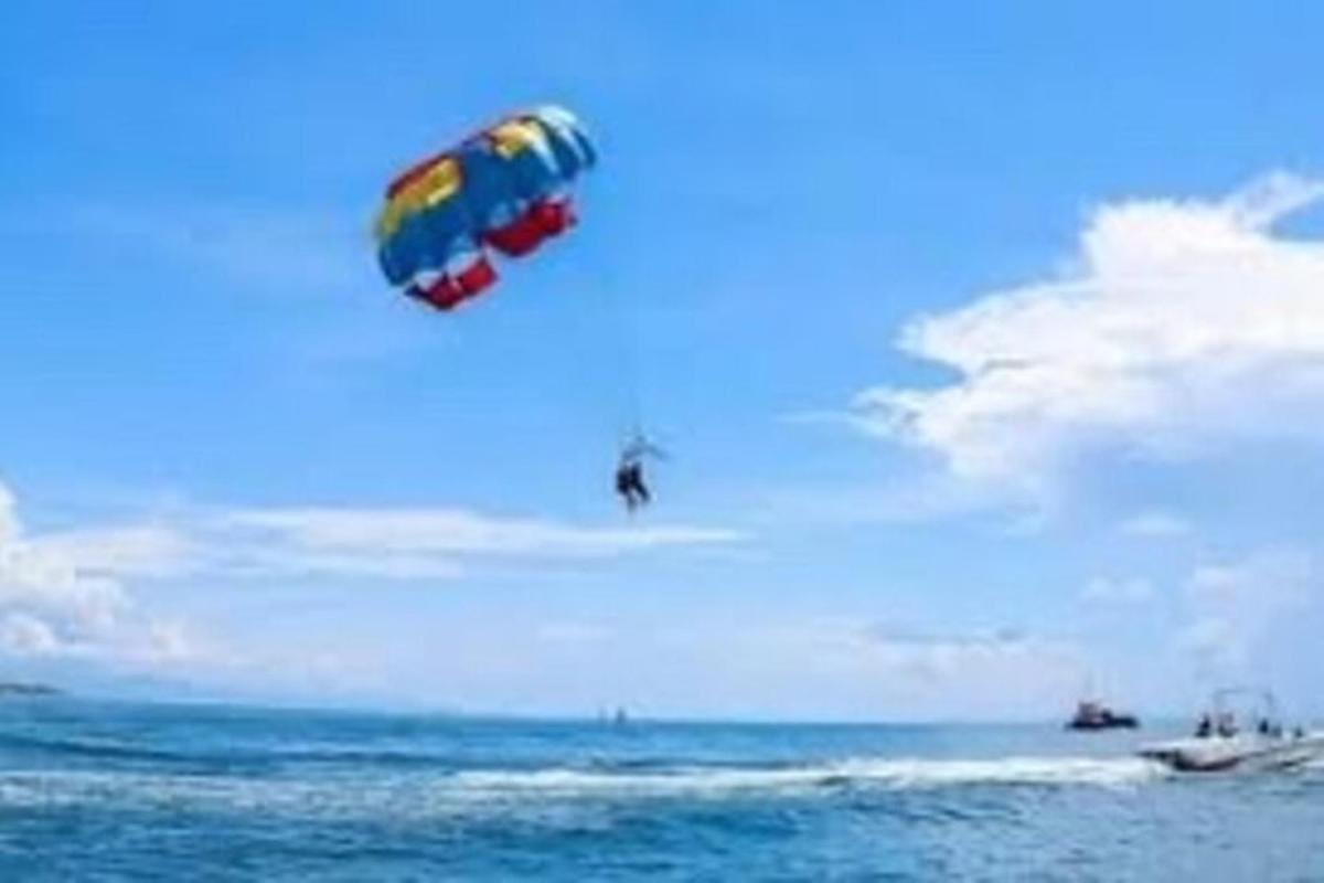 una persona che fa volare un aquilone sopra l'oceano