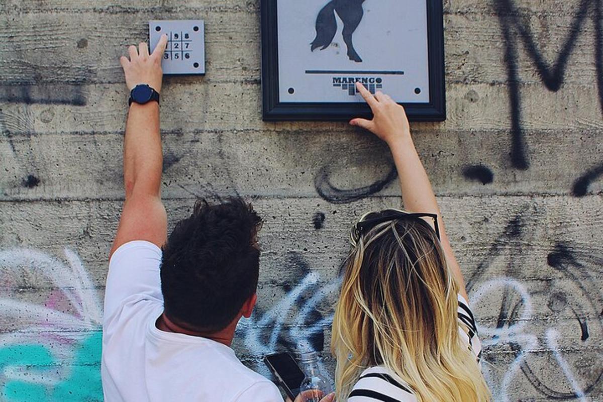 un uomo e una donna che cercano di raggiungere un cartello su un muro