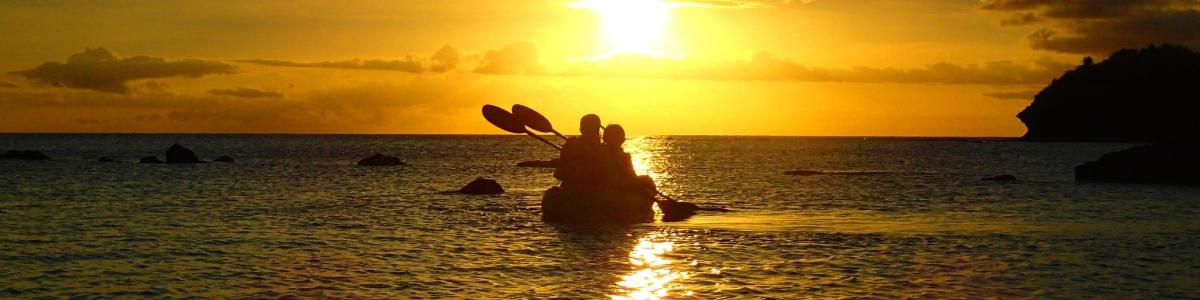 日没時に海に立っている人