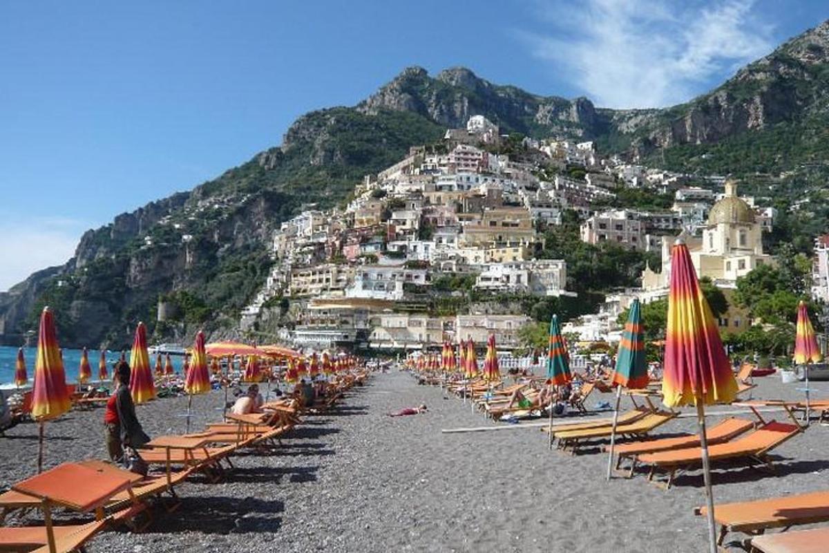 um monte de cadeiras de praia e guarda-sóis em uma praia