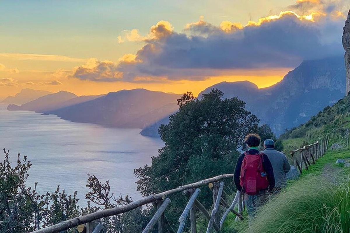 doi oameni mergând pe un deal cu vedere la ocean